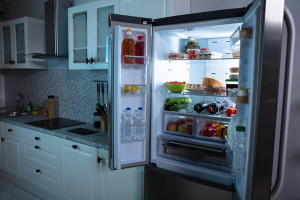 An Open Refrigerator Full Of Fruits, Juice And Fresh Vegetables In Kitchen