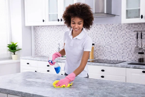 若い女性が洗浄スプレー ボトルとナプキンの汚れた台所のカウンターのクローズ アップ — ストック写真