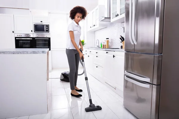 Close Uma Jovem Mulher Limpando Chão Cozinha Branca Com Aspirador — Fotografia de Stock