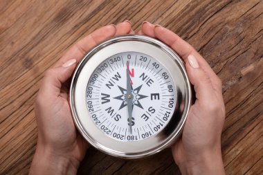 Pusula ahşap Resepsiyon üzerinde tutan bir kadın eli yükseltilmiş görünümünü