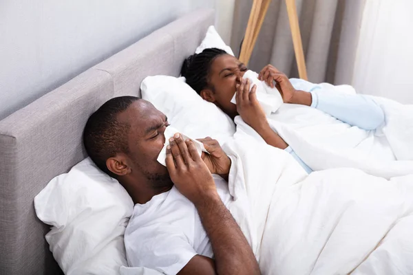 Sick African Young Couple Lying Bed Blowing Nose Bedroom — Stock Photo, Image