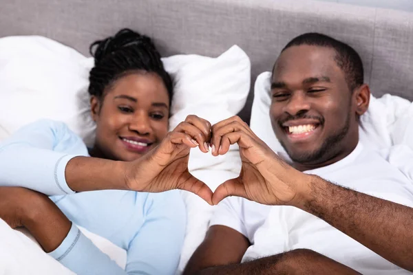 Casal Africano Feliz Deitado Cama Fazendo Forma Coração — Fotografia de Stock