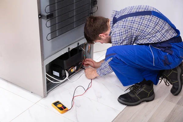 Side View Male Repairman Checking Refrigerator Digital Multimeter Home — стоковое фото
