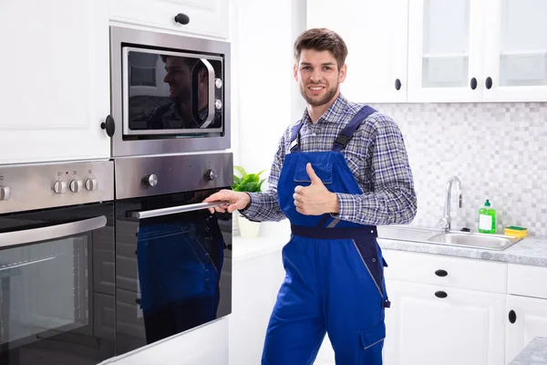 ジェスチャーを親指アップ表示キッチンに立つ男性技術者のクローズアップ — ストック写真