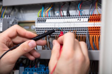 Sigorta kutusu multimetre ile inceleyerek bir erkek elektrikçi Close-up