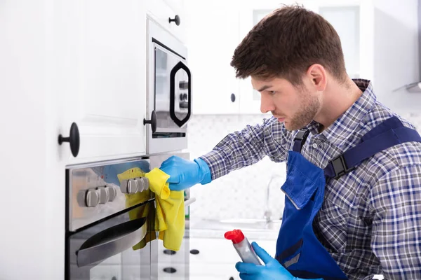 Nahaufnahme Von Ein Janitor Hand Putzen Ofen Die Küche — Stockfoto