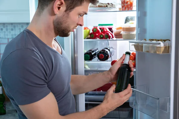 Young Man Holding Beer Bottle Standing Front Refrigerator — Stock Photo, Image