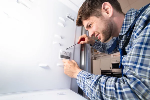 Trabalhador Masculino Reparando Refrigerador Com Ferramenta Mão Sala Cozinha — Fotografia de Stock