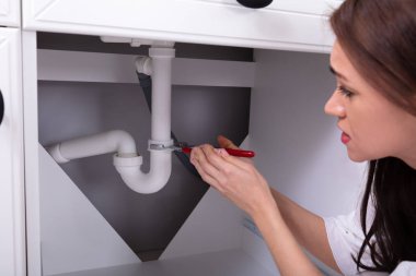 Ayarlanabilir anahtarı ile lavabo tamiri genç bir kadının yakın çekim