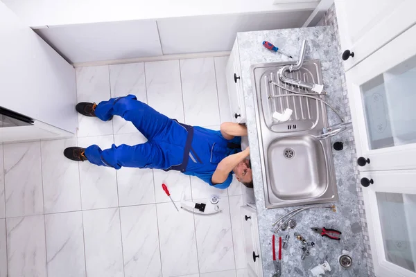 Encanador Masculino Deitado Chão Fixação Tubulação Para Dissipador Cozinha — Fotografia de Stock