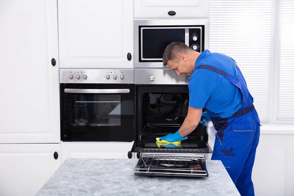 Close Smiling Male Janitor Cleaning Oven Yellow Napkin Kitchen — Stock Photo, Image