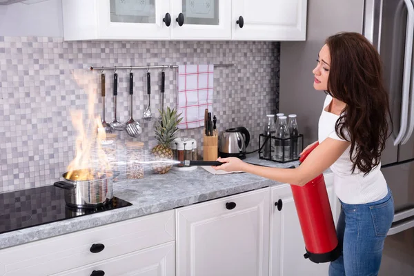Woman Using Fire Extinguisher Stop Fire Burning Cooking Pot Kitchen — Stock Photo, Image