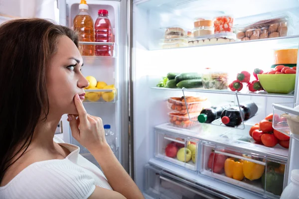 漂亮的女人寻找冰箱里的食物 — 图库照片