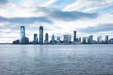 Jersey City bulutlu gökyüzü karşı Hudson Nehri ile gökyüzü kazıyıcılar görünümünü