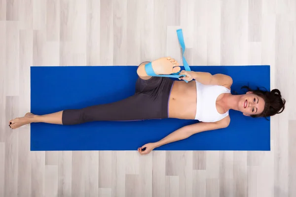 Genç Kadın Egzersiz Fitness Mat Evde Yoga Kemer Kullanarak — Stok fotoğraf