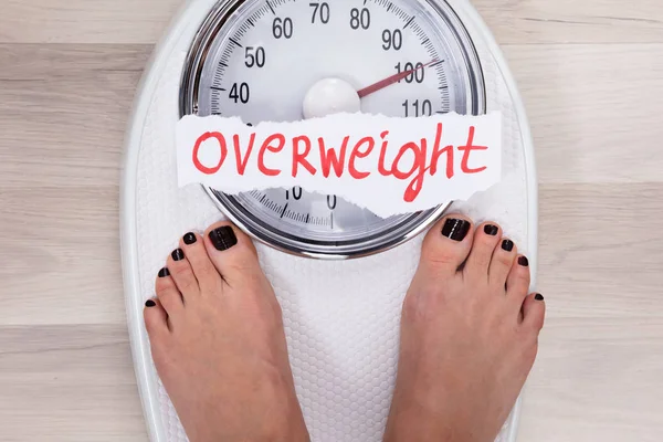 体重計での女性の足のクローズアップは 太りすぎを示す — ストック写真