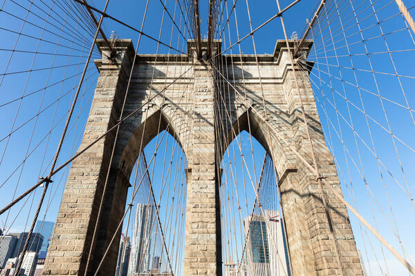 Low Angle View Of Brooklyn Bridge In New York City Against Blue Sky