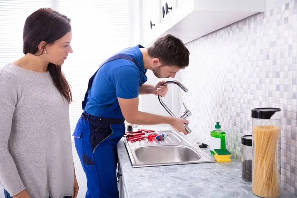 Junge Frau Schaut Männlichen Installateur Der Wasserhahn Küche Repariert — Stockfoto