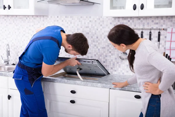 Mulher Olhando Para Serviceman Uniforme Fixando Fogão Indução Cozinha — Fotografia de Stock