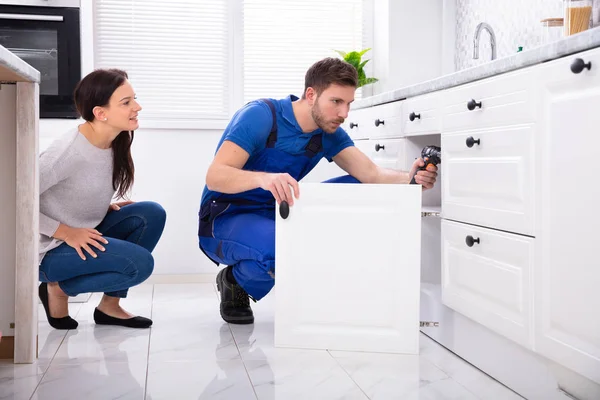 Woman Looking Male Handyman Installing Cabinet Door Kitchen — Stock Photo, Image