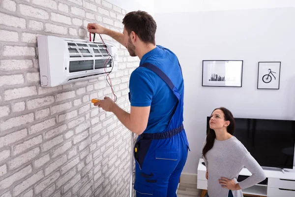 Lächelnde Frau Beim Anblick Eines Technikers Der Hause Eine Klimaanlage — Stockfoto