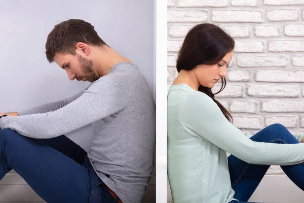 Sad Young Couple Sitting Back To Back On Floor At Home
