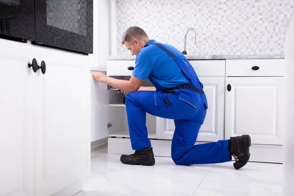 Side View Male Handyman Fixing Cabinet Door Using Screwdriver Kitchen — стоковое фото