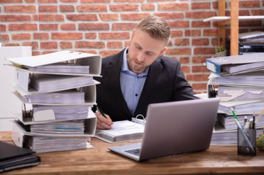 Resepsiyon Office klasörlerinde yığını ile çalışan işadamı önden görünümü