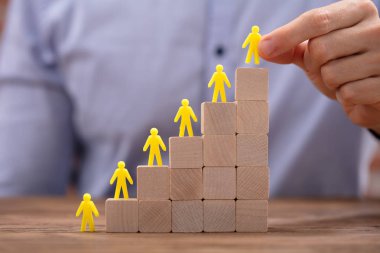 Ofisteki tahta blokların tepesine çıkan sarı insan figürlerine yakın çekim