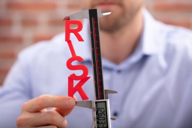 İnsan eli, Dijital Elektronik Vernier Kaliper ile Kırmızı Risk Kelimesini Ölçüyor