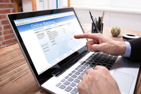 ノートパソコン画面にオンラインバンキングアプリケーションを表示するビジネスマンのクローズアップ — ストック写真
