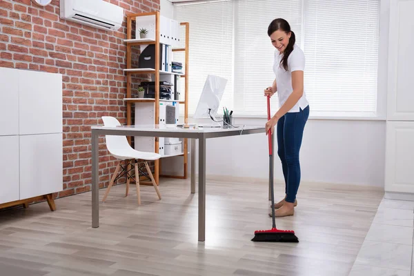 Ofiste Süpürgeyle Temizlik Yapan Mutlu Genç Kadın Temizlikçi — Stok fotoğraf