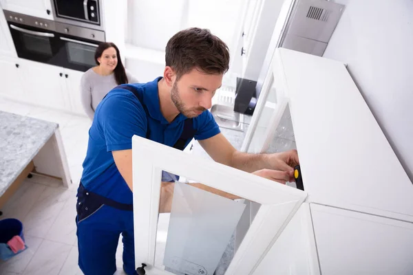 Žena Při Pohledu Mužské Údržbář Instalaci Dveří Skříně Kuchyni — Stock fotografie