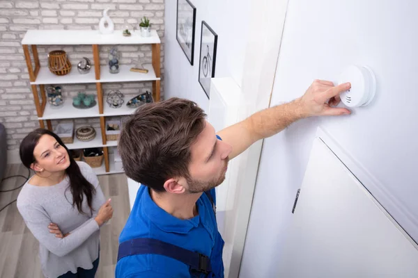 Jolie Femme Debout Près Réparateur Installant Détecteur Fumée Sur Mur — Photo