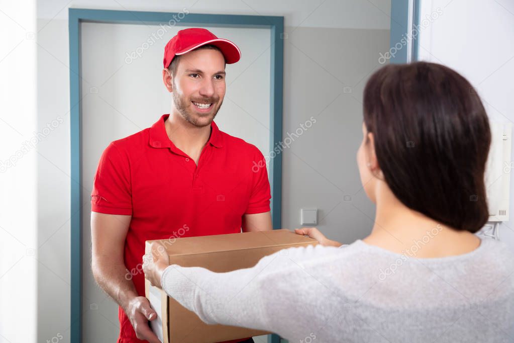 Close-up Of Woman Taking Cardboard Box From Delivery Man
