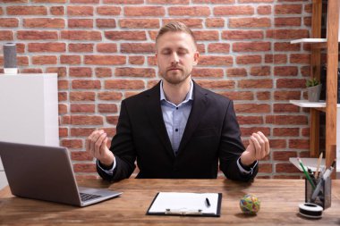 Ofiste Meditasyon yaparken rahat genç işadamı