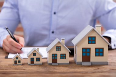 Ofis masasında ev modeli ile hesap makinesi kullanma fatura hesaplama işadamı Close-Up