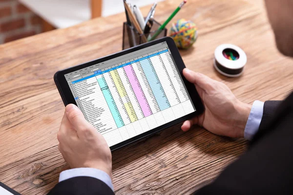 机の上のデジタル タブレット上のデータの分析の実業家の手の立面図 — ストック写真