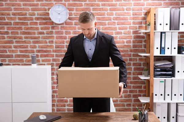 Junger Geschäftsmann Packt Arbeitsplatz Seine Habseligkeiten Einen Karton — Stockfoto