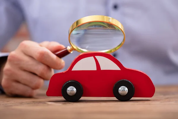 Közelkép Egy Személy Kezét Gazdaság Nagyító Látszó Piros Toy Car — Stock Fotó