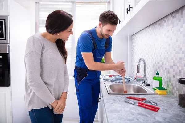Happy Woman Looking Male Plumber Using Plunger Kitchen Sink — Stock Photo, Image