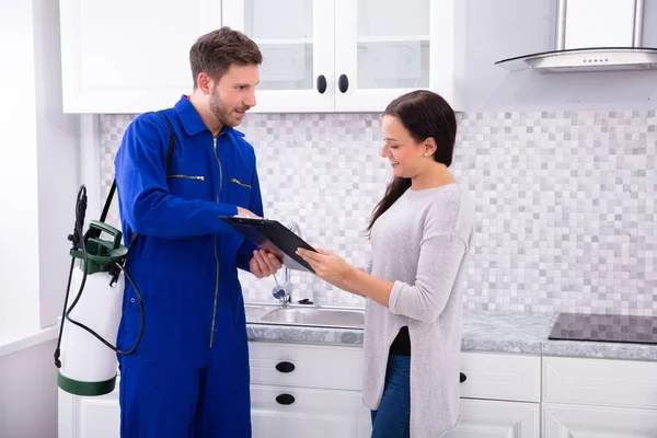 Trabajador Control Plagas Masculino Joven Que Muestra Factura Mujer Cocina — Foto de Stock