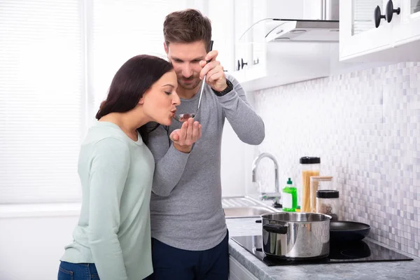 Jovem Fazendo Sua Esposa Para Saborear Alimento Cozinha — Fotografia de Stock