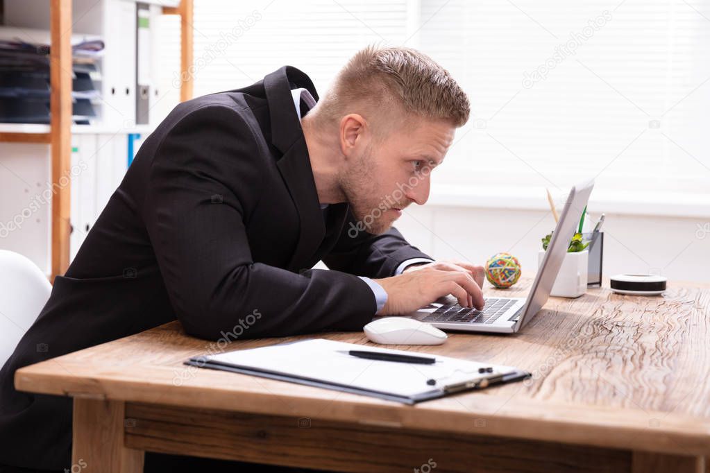 Concentrated Businessman Looking At Laptop Working In Office