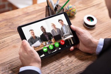 Bir işadamı video konferans onun meslektaşları ile yükseltilmiş görünümünü dijital Tablet