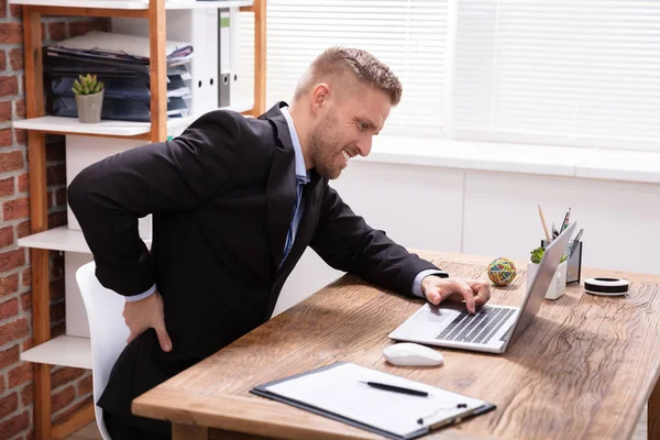 Guapo Joven Ejecutivo Teniendo Dolor Espalda Trabajando Ordenador Portátil Oficina — Foto de Stock