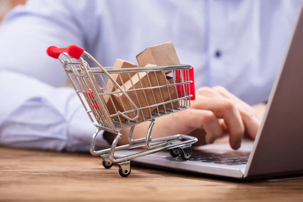 Close Man Using Laptop Miniature Cardboard Boxes Shopping Trolley — Stock Photo, Image