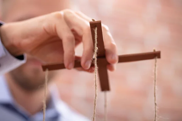 Close Businessperson Hand Manipulating Marionette String — Stock Photo, Image