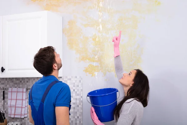 Young Woman Blue Bucket Showing Water Leaking Damage Ceiling Serviceman — Stock Photo, Image