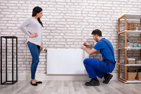 Hermosa Mujer Mirando Joven Plomero Masculino Uniforme Que Instala Radiador — Foto de Stock